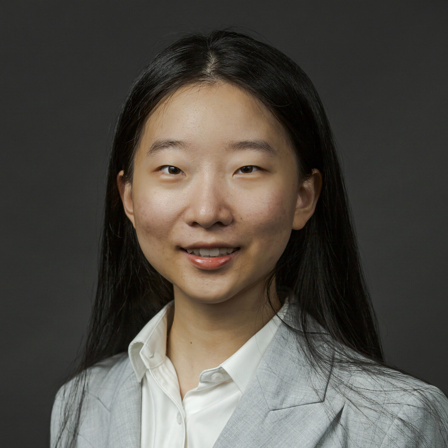 A person's headshot before a grey background
